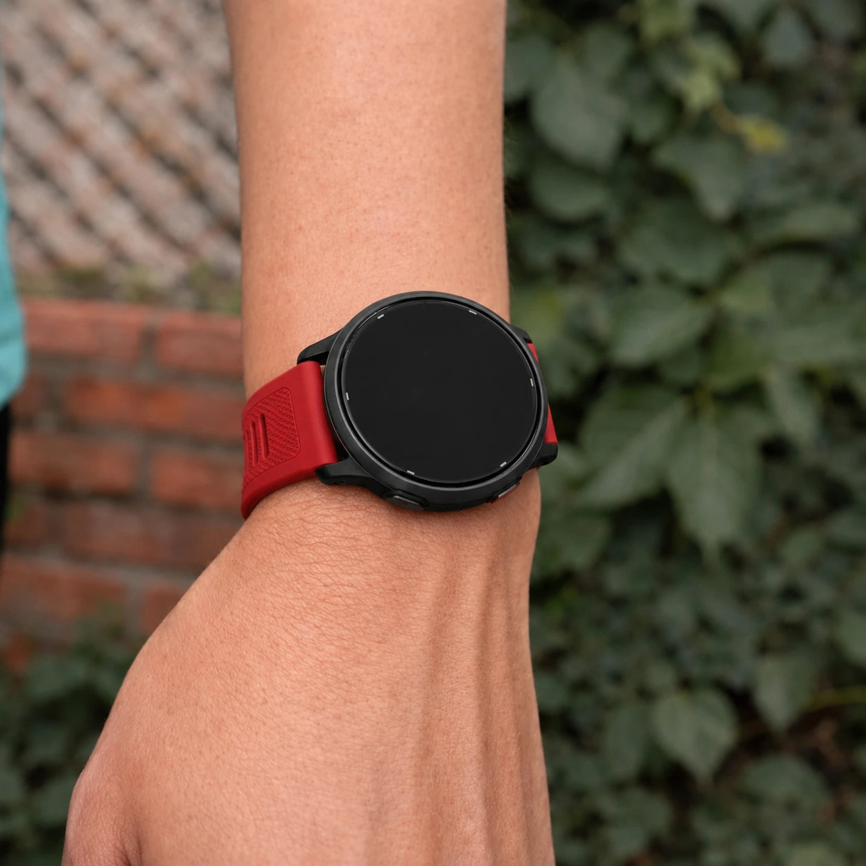 Close-up of a red Garmin Vivoactive 5 silicone strap worn on the wrist