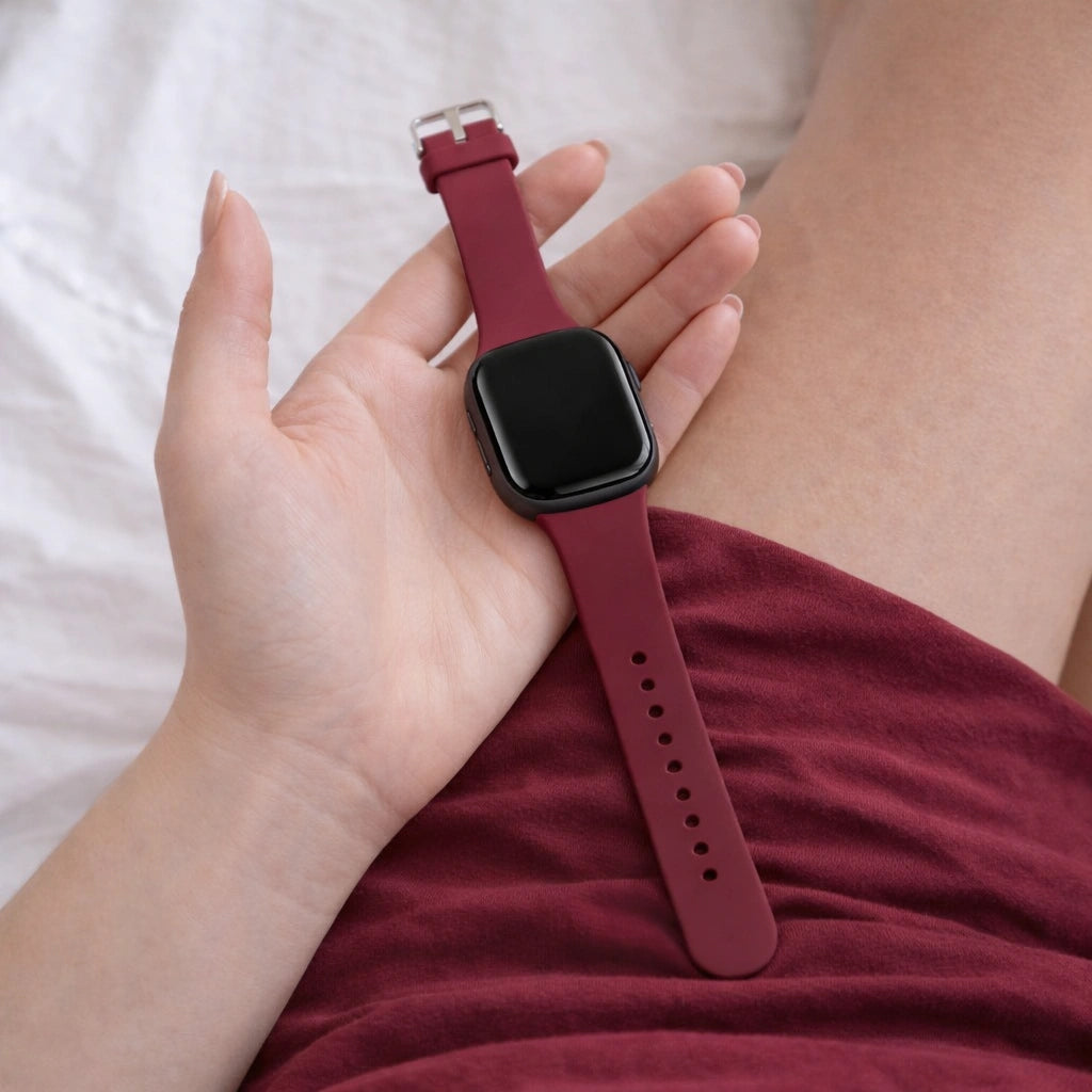 Fitbit Versa 3 wristband in wine red silicone held in hand for close-up detail