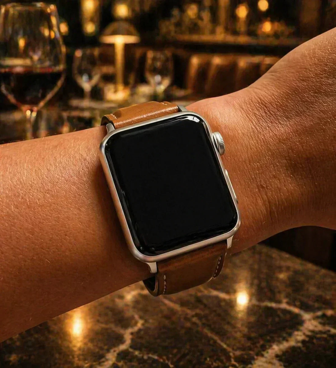 Apple Watch with dark case and metal strap styled in a smart evening bar setting