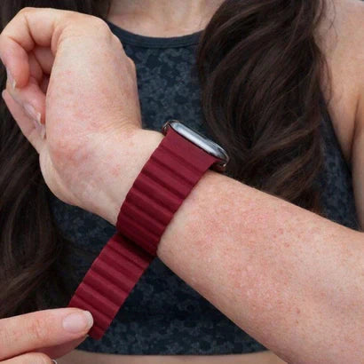 Best Fitbit strap for eczema in a wine red silicone design, shown on sensitive skin with mild eczema
