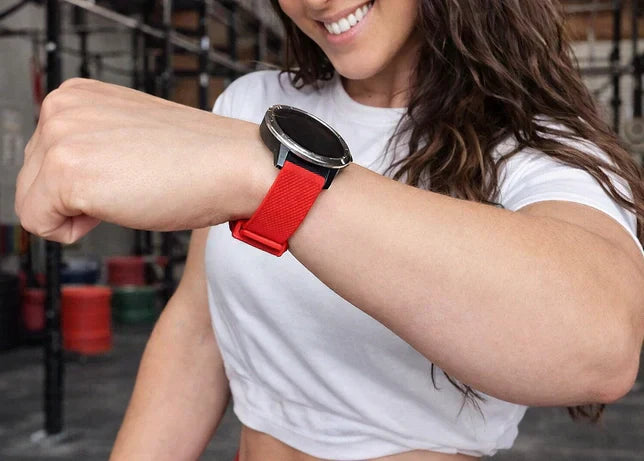 Female CrossFit athlete wearing a Garmin watch with a secure red strap during gym training