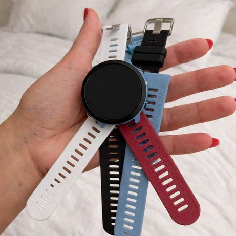Choosing the best Garmin watch strap for sleeping, shown in multiple soft silicone colours on a bed