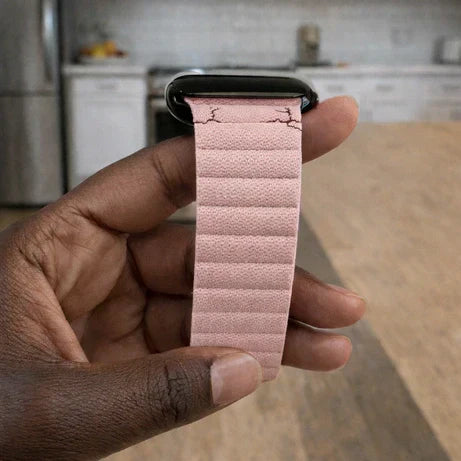 Pink Fitbit strap with visible cracking near the connector, showing common strap damage