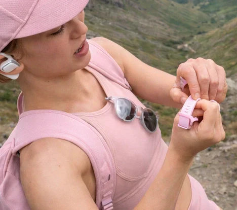 Person attempting to remove a Fitbit strap outdoors after it becomes stuck