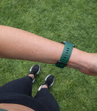 Is the Fitbit Versa 2 22mm compatible with pine green straps, shown worn outdoors on the wrist