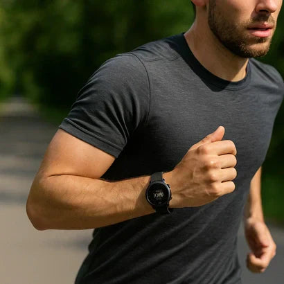Runner jogging outdoors wearing a Garmin smartwatch with a black silicone strap, showing the best Garmin band for sensitive skin.