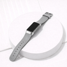 Grey leather Fitbit Charge 6 band worn on the wrist with silver case