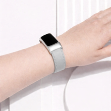 Grey leather Fitbit Charge 6 strap worn on the wrist with silver case