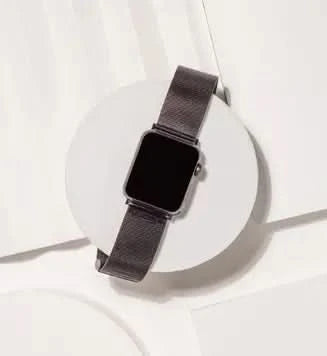 Black stainless steel strap on Apple Watch SE, styled for smart or formal wear.