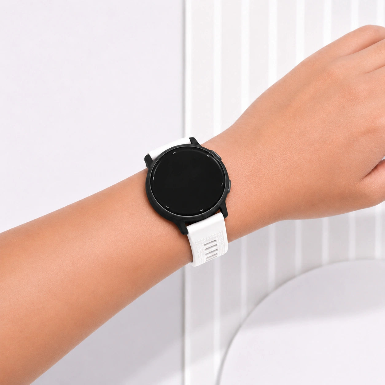 Close-up of a white Garmin Vivoactive 5 silicone strap worn on the wrist