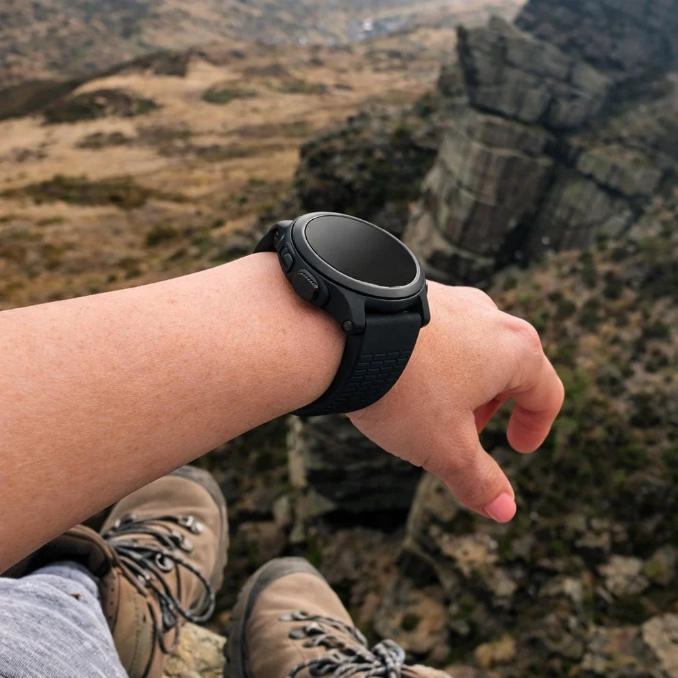 Black Garmin Fenix 8 strap worn during outdoor hiking adventure with rugged mountain scenery