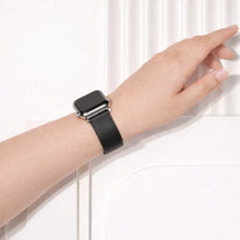 Black leather Apple Watch strap shown worn on the wrist.