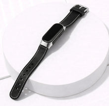 Black leather strap for Fitbit Inspire 3 shown in a flat lay