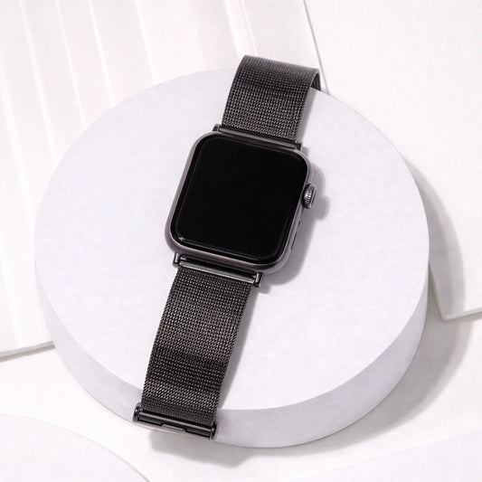 Black metal Apple Watch band displayed on a stand with a breathable mesh design