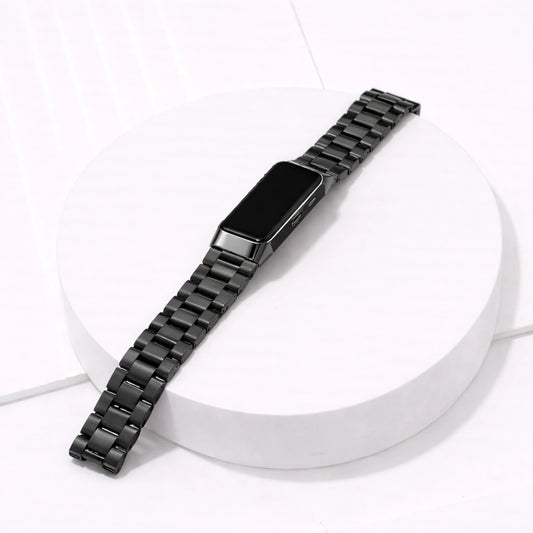 Fitbit Charge 5 black metal watch strap with stainless steel links on white platform