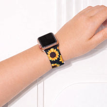 Apple Watch worn on wrist with black sunflower patterned silicone band.
