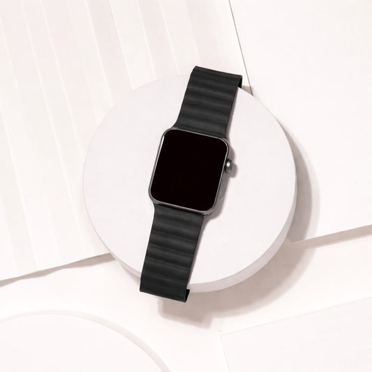 Black two-part leather Apple Watch strap displayed on a white platform.