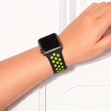 Apple Watch worn on wrist with black and yellow perforated sport band designed for airflow and comfort.