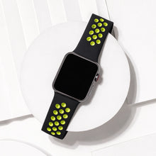 Black and yellow ventilated sport strap for Apple Watch displayed on a white platform background.