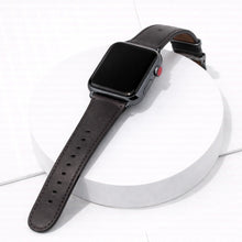 Dark brown leather Apple Watch band displayed on a white platform.