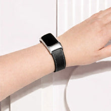 Black leather watch strap fitted on a Fitbit Charge 6 worn on the wrist