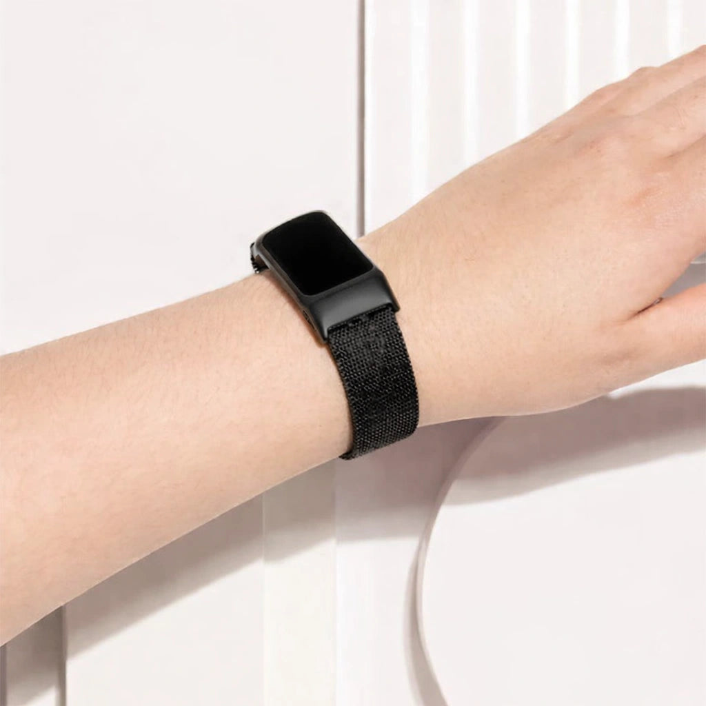 Metallic black mesh band fitted to a Fitbit Charge 6 worn on the wrist