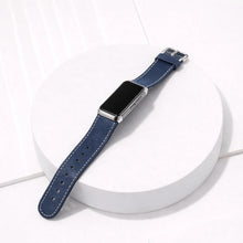 Blue leather strap for Fitbit Charge 6 displayed flat on a white surface