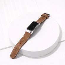 Dark brown leather strap for Fitbit Charge 6 displayed on a white flat lay surface