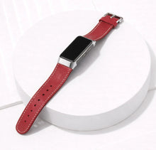Red leather watch strap for Fitbit Charge 6 laid flat on a white surface