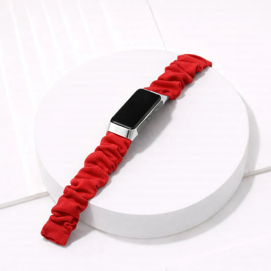 Red scrunchie-style strap for Fitbit Charge 6 shown in a clean flat lay setting
