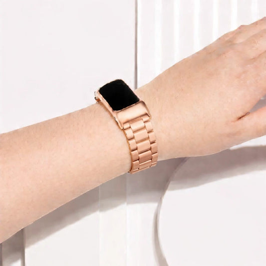 Rose gold stainless steel link strap worn on the wrist with Fitbit Charge 6