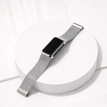 Silver metal mesh strap for Fitbit Charge 6 displayed on a white platform