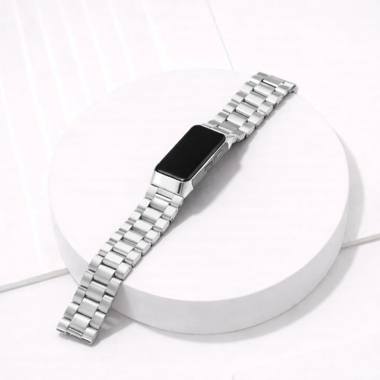 Silver stainless steel replacement link strap for Fitbit Charge 6 shown in a flat lay studio setting