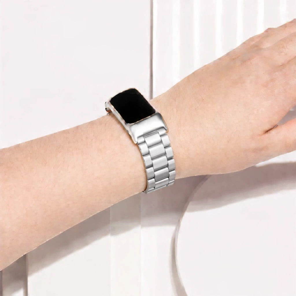 Silver stainless steel link watch strap worn on the wrist with Fitbit Charge 6