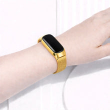 Fitbit Inspire 2 worn with a gold metal mesh band on the wrist