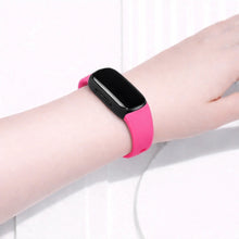 Hot pink Fitbit Inspire 2 band worn on the wrist for a bold everyday look