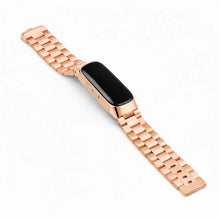 Rose gold metal link strap for Fitbit Inspire 2 on a white background