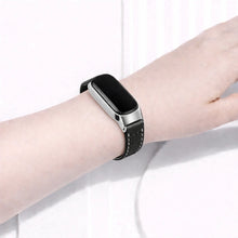 Black leather watch strap worn on a Fitbit Inspire 3