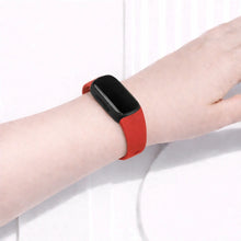 Red watch band worn on a Fitbit Inspire 3