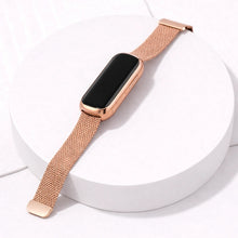 Rose gold mesh Fitbit Luxe wrist strap attached to rounded Luxe tracker with black display