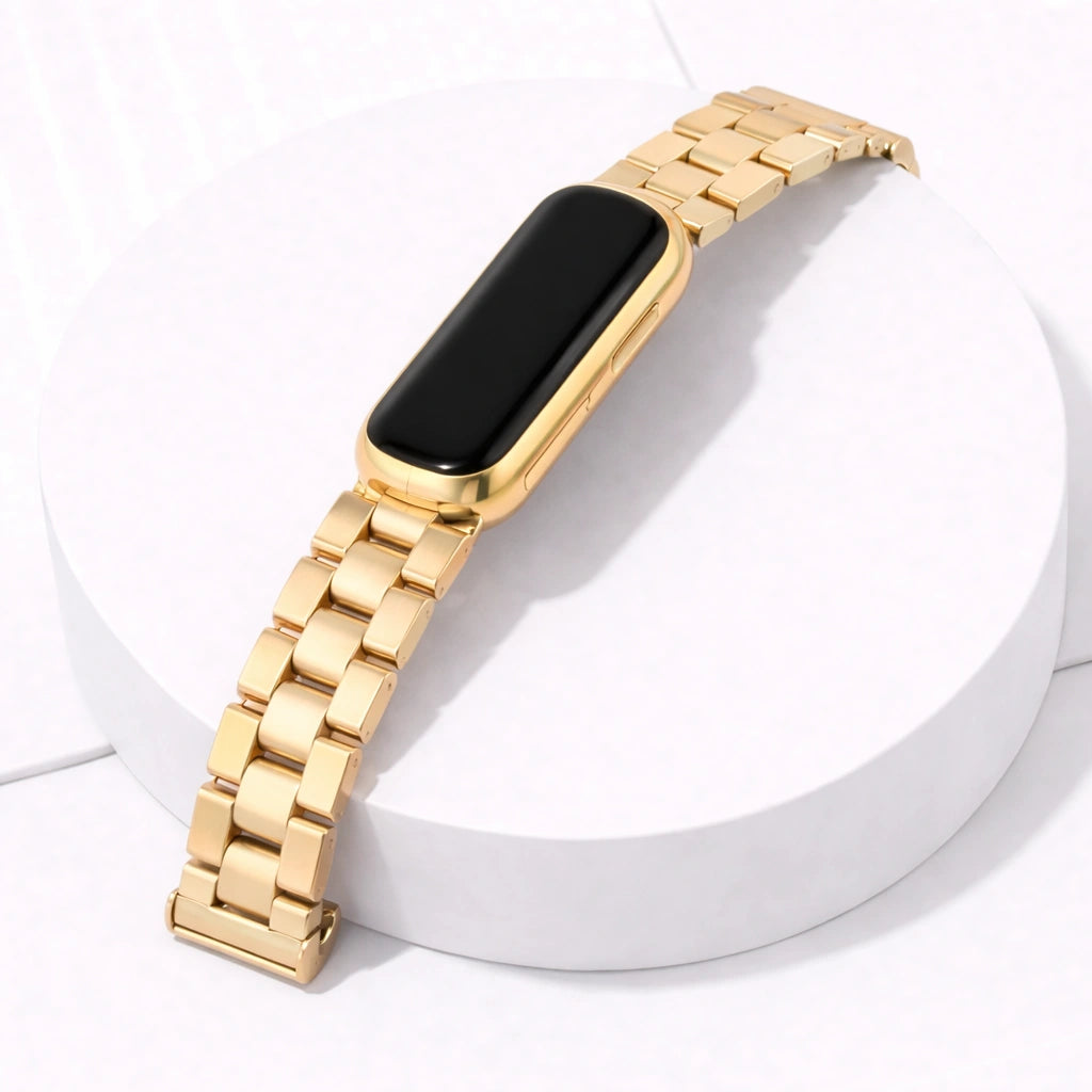 Fitbit Luxe gold metal bracelet watch strap attached to tracker on white display stand