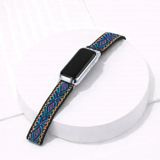 Purple and blue print pattern nylon Fitbit Luxe wristband and device on white display stand
