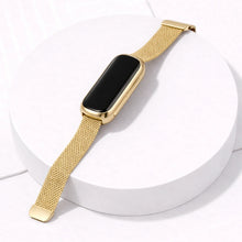 Gold milanese Fitbit Luxe strap attached to rounded Luxe tracker on white display stand