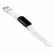 White silicone Fitbit Luxe straps attached to tracker with black display and silver buckle