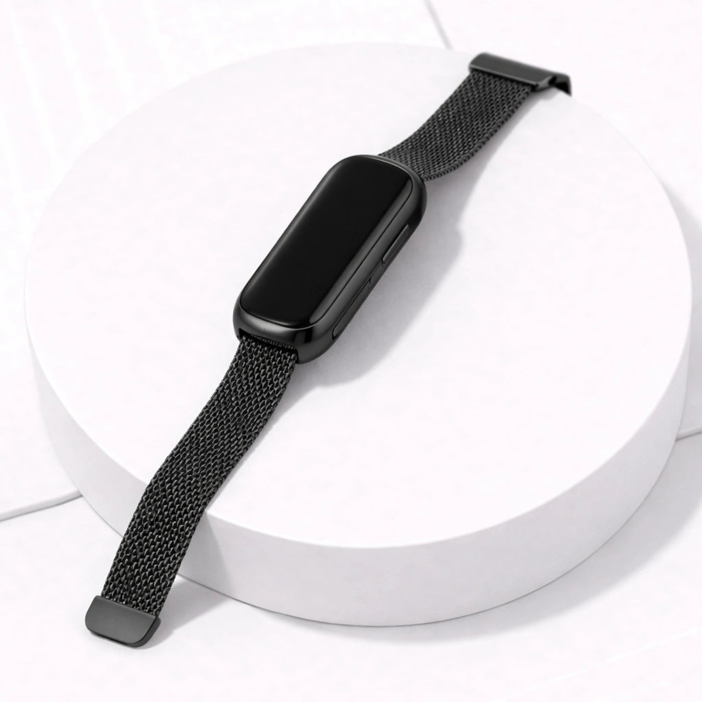 Metal black mesh Fitbit Luxe watch strap attached to rounded black Luxe tracker on display stand