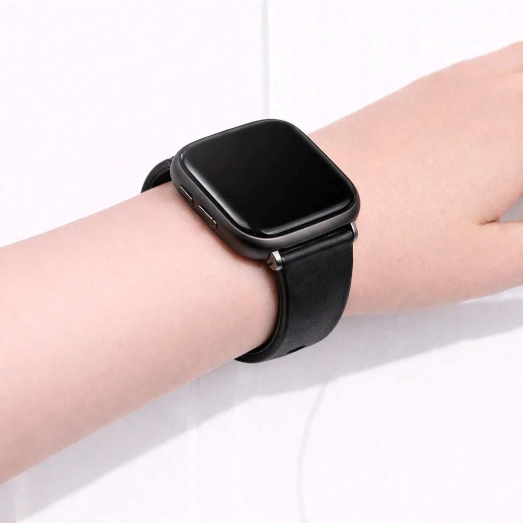 Black leather wristband fitted to a Fitbit Versa 2 shown in close-up on wrist