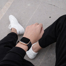 Black silicone strap worn with Fitbit Versa 2 in a relaxed outdoor lifestyle setting