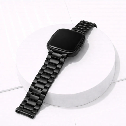 Metal black stainless steel strap for Fitbit Versa 2 displayed on a white stand