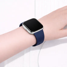 Fitbit Versa 2 watch worn with a navy blue silicone band for everyday comfort