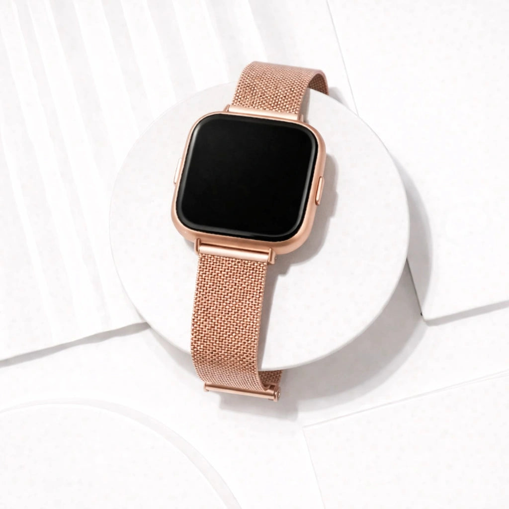 Rose gold Milanese style strap for Fitbit Versa 2 displayed on a stand, highlighting the breathable mesh design.